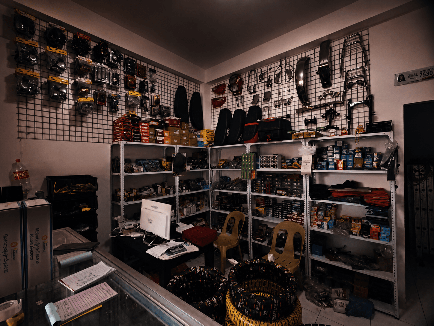 Parts counter backed by shelves stocked with motorcycle parts and accessories